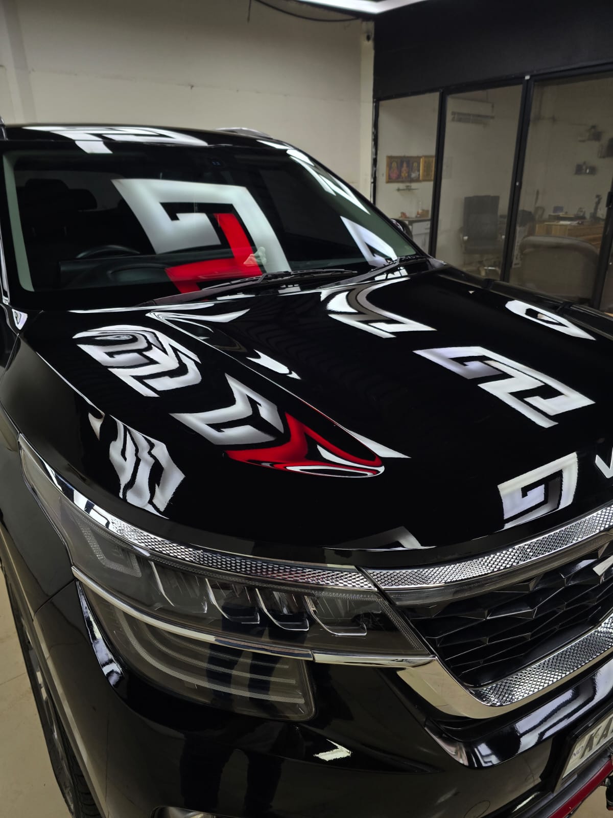 Glossy black car hood reflecting Octa 4 studio lights